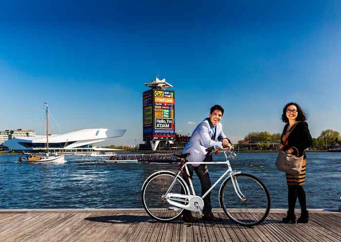 Amsterdam, man met fiets, vrouw, aan de rivier het IJ